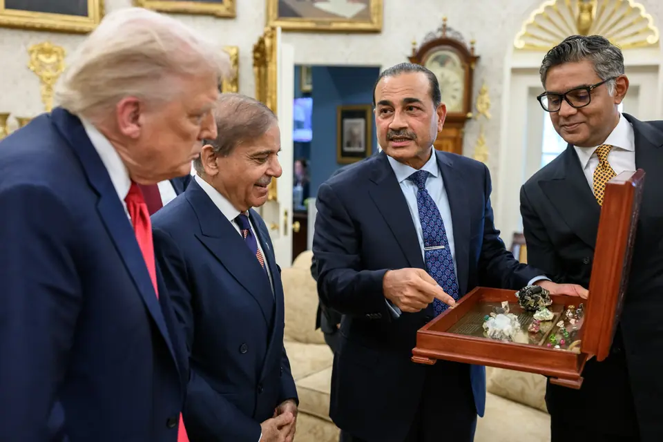 Field Marshal Asim Munir, with Prime Minister Shehbaz Sharif beside him, shows President Donald Trump an open case of stones among gifts from Pakistan in the Oval Office, 25 September 2025