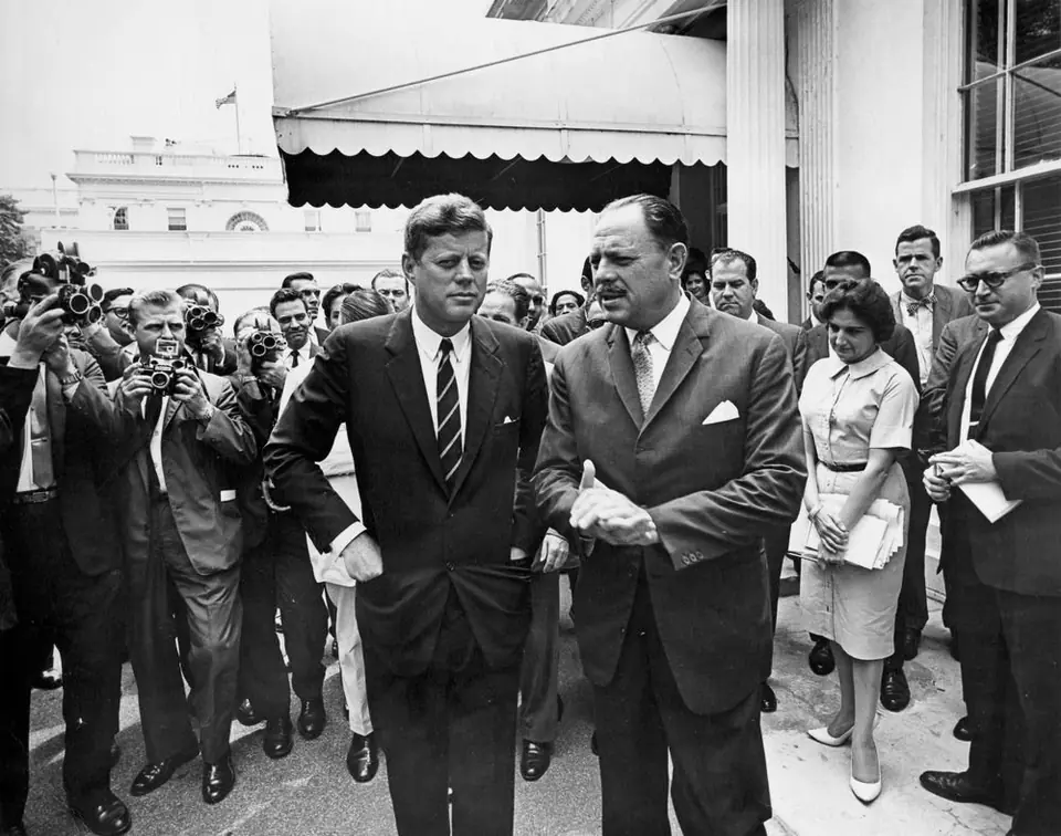 President John F. Kennedy and President Mohammad Ayub Khan of Pakistan at the West Wing entrance of the White House, with photographers and reporters behind them, 13 July 1961