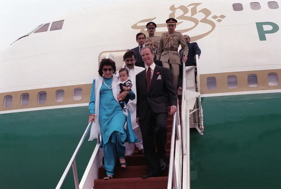 Prime Minister Benazir Bhutto of Pakistan, carrying her son Bilawal Bhutto Zardari, leaves her aircraft on arrival for a state visit at Andrews Air Force Base, 5 June 1989